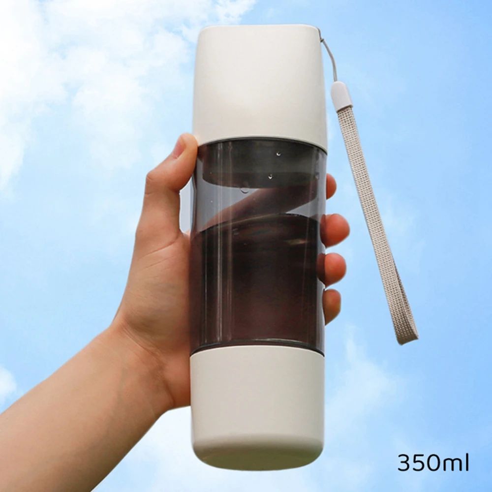 Hand holding a white and clear water bottle with a blue sky background